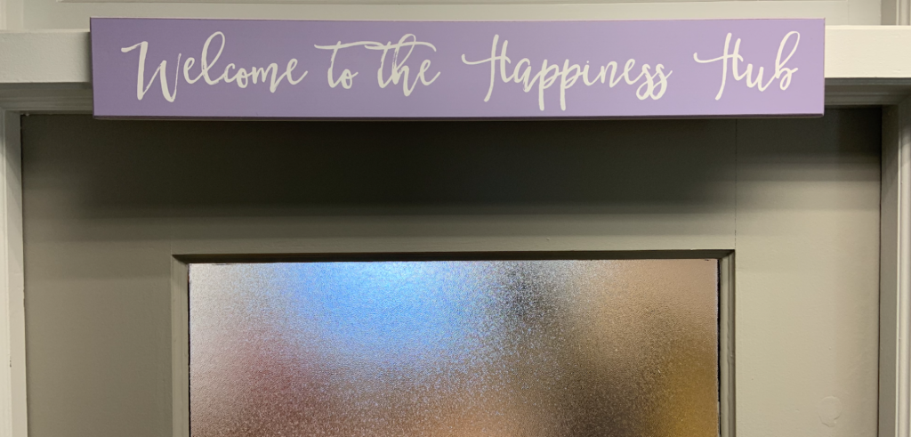 Welcome to the Happiness Hub' board at the entrance
