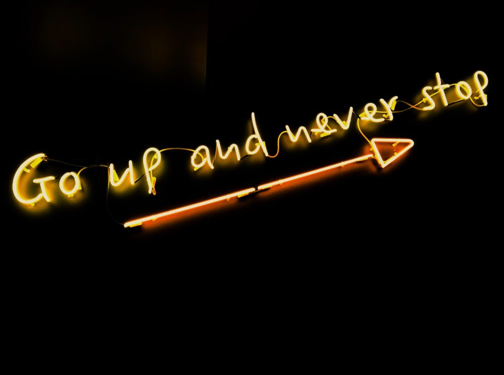 mastering your morning with motivation - a picture of a neon sign that says go up and never stop 