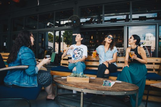 a few women enjoy happy hour chatting about their cool job