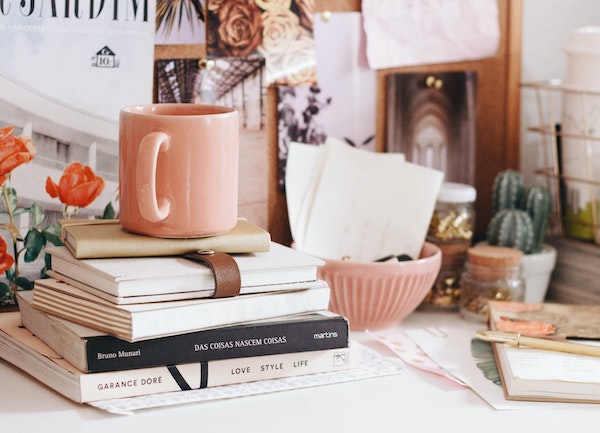 Desk with books and coffee. journaling questions to market yourself