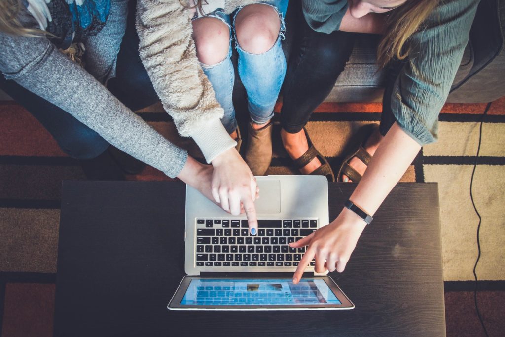 Girls pointing at a laptop and working together