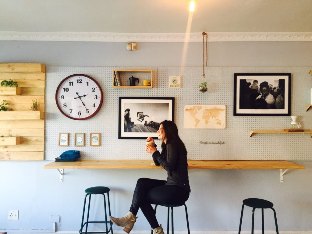 A woman smiling and drinking coffee in a cafe