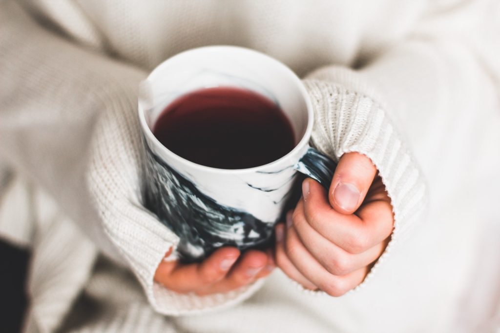 A women holding a black coffee mug