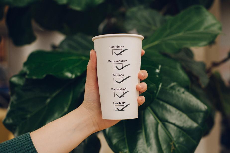 A coffee cup with good qualities checked off on it