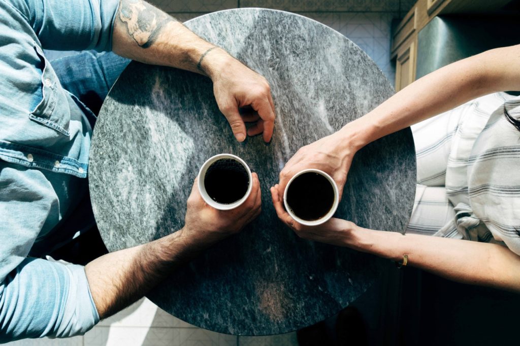 birds-eye view of two people at a table holding coffee
