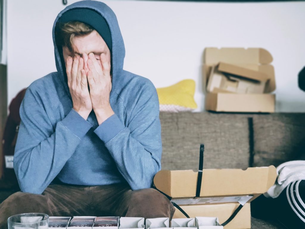 A stressed guy holding his face with both hands
