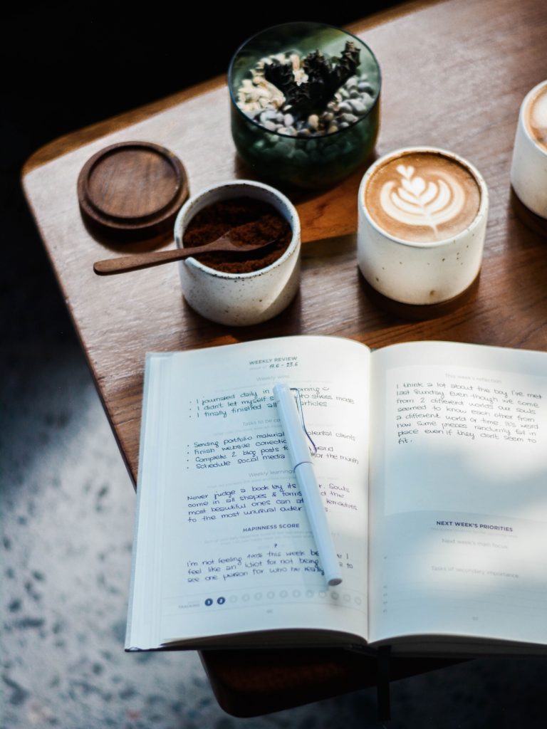 A journal and coffee on the table
