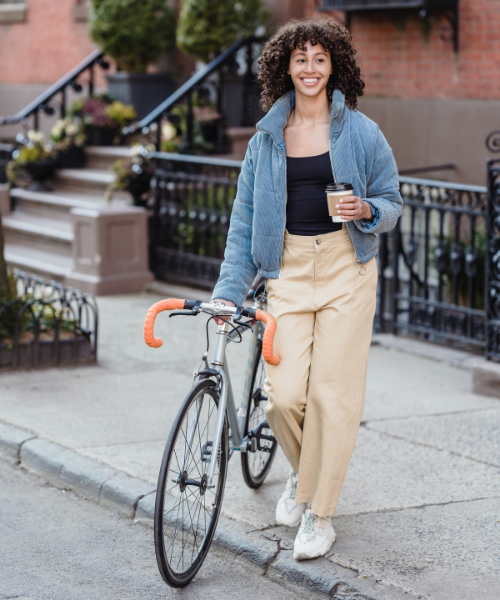 A woman walks with a bike