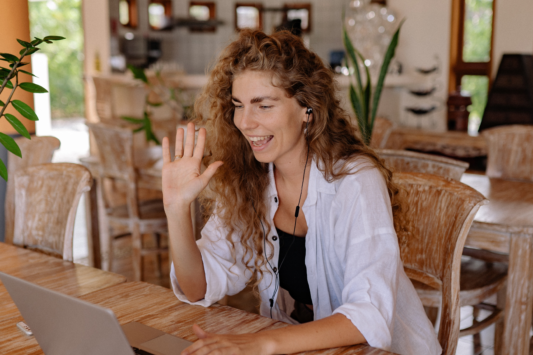 woman smiling waving at computer