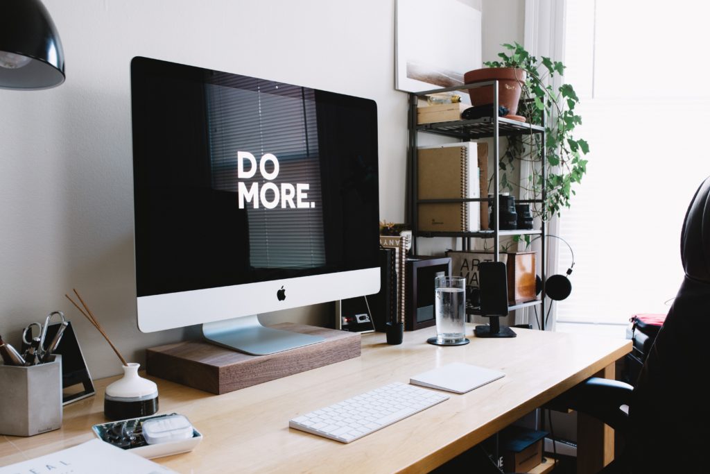 a stylish desk set-up with a desktop computer that says "Do More." on screen.