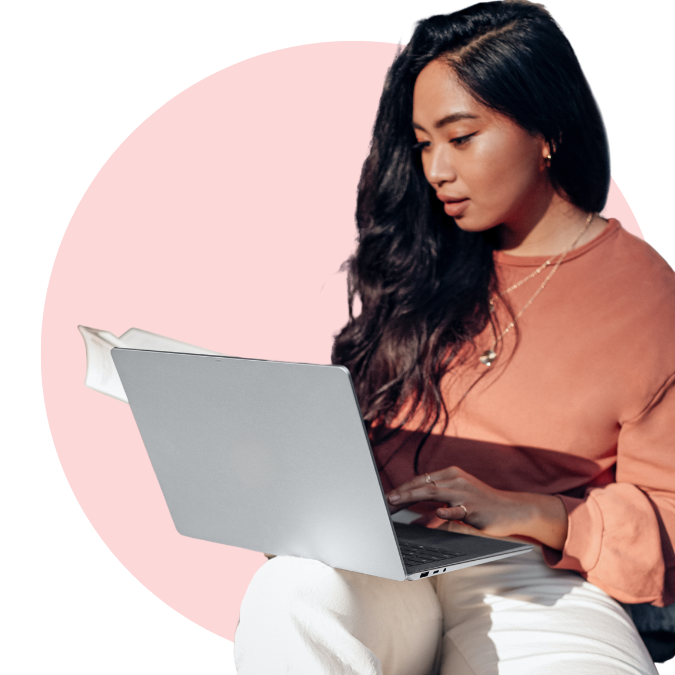 woman working on laptop in front of pink circle graphic
