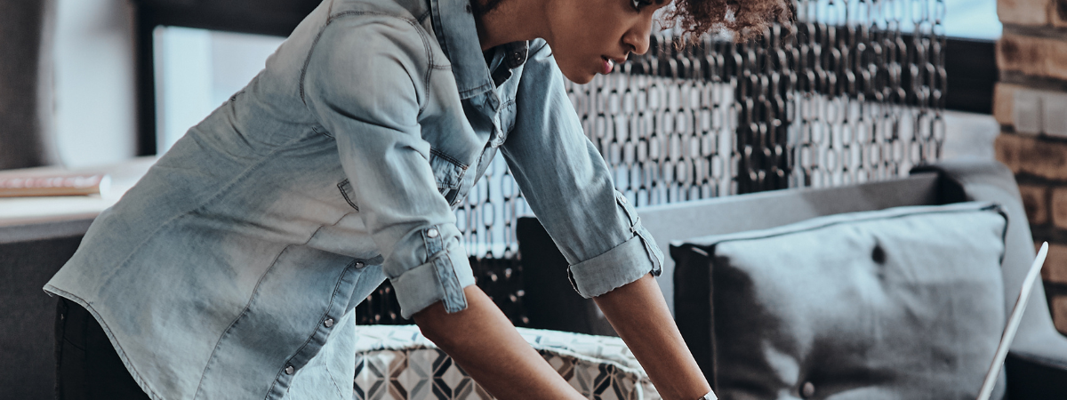 woman standing looking down at her laptop