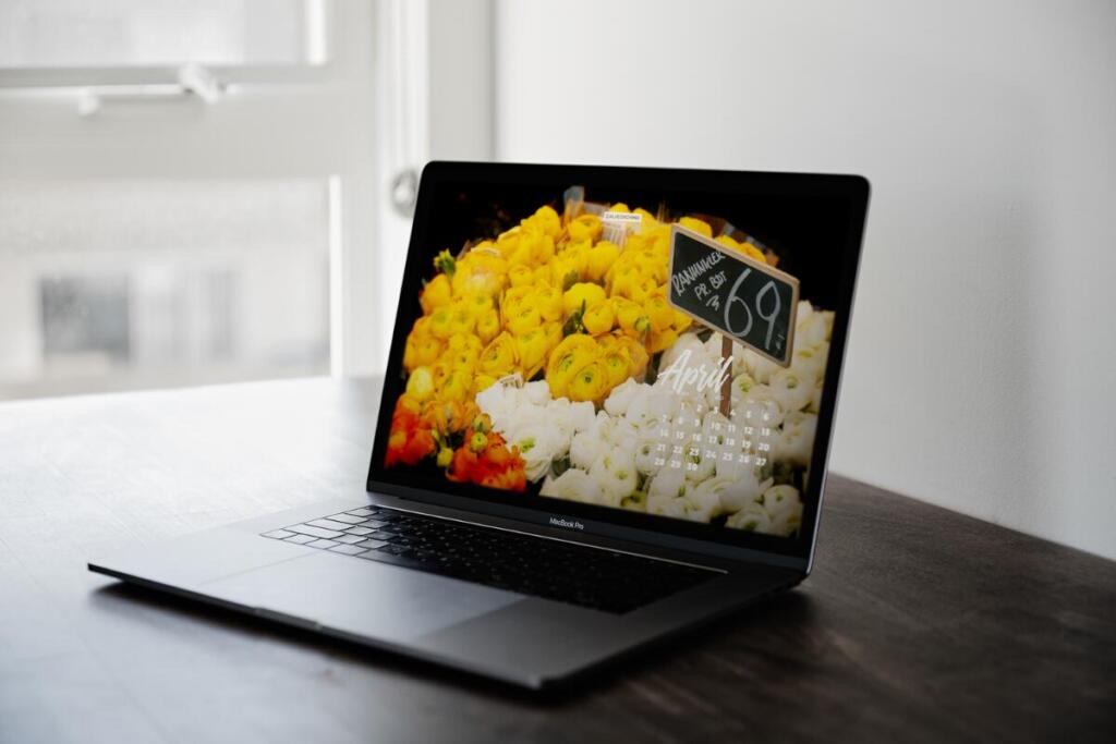 laptop with flowers in the background with April 2024 calendar on it