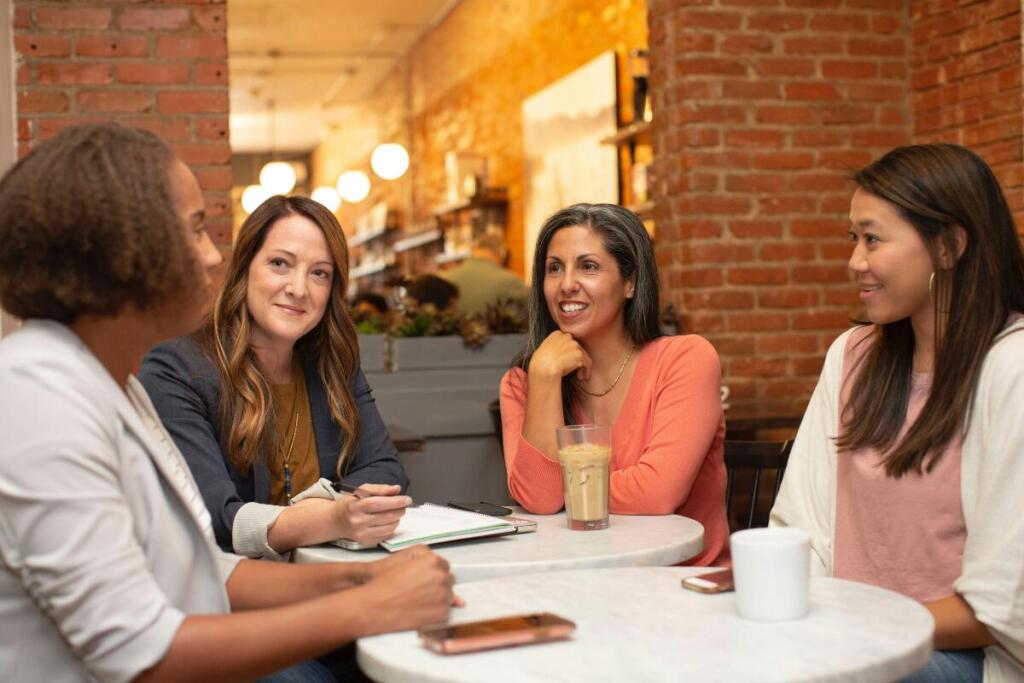 Group of 4 women talking over coffee