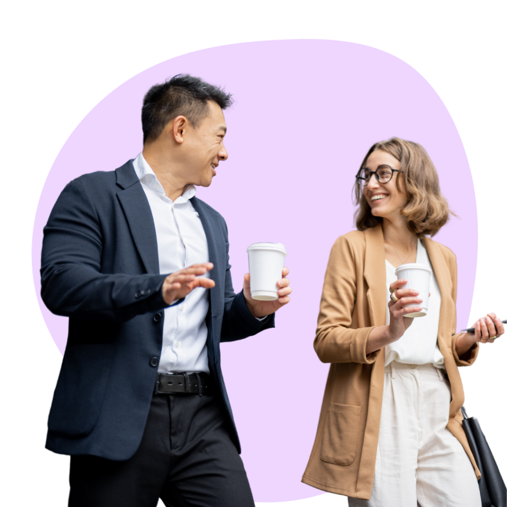 two professionals walking and talking together holding coffee