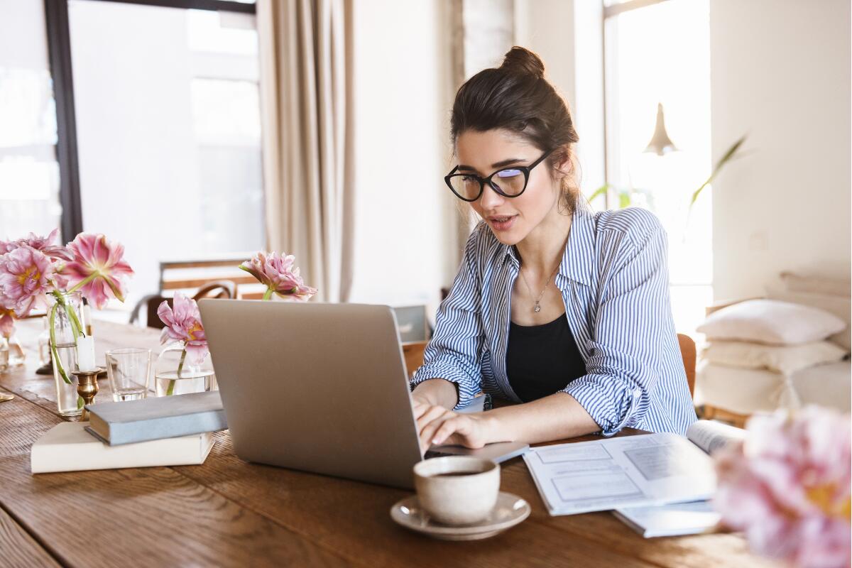 Woman on laptop with cup of coffee