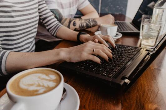 woman typing on laptop at a cafe