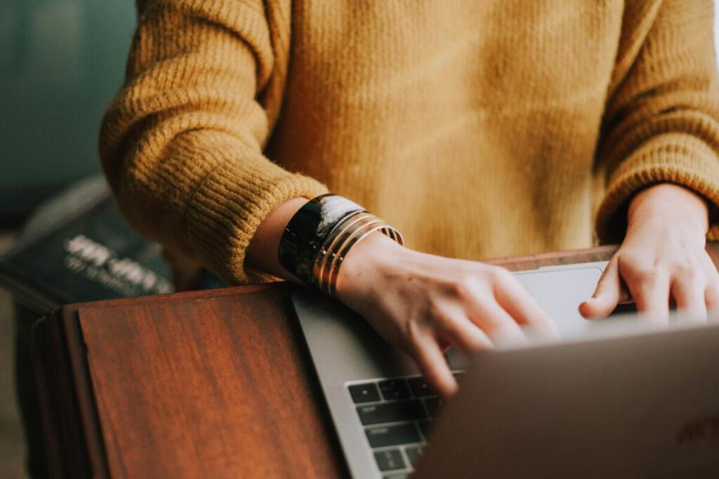 Person typing on laptop, close up