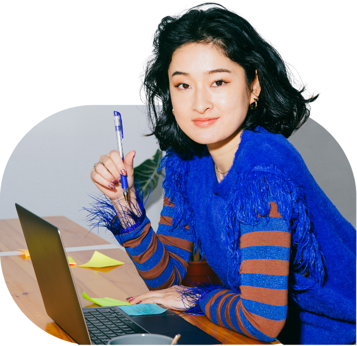 young woman happy and enjoying her work at an office wearing a funky cobalt blue feathered sweater