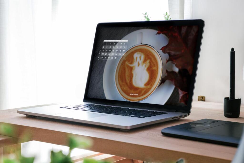 October tech background calendar with a picture of a latte and foam shaped as a ghost on it