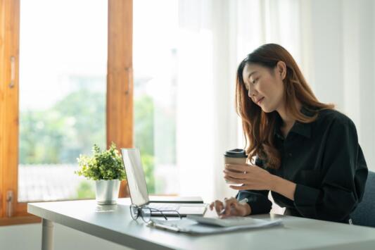 young professional working on laptap and taking notes