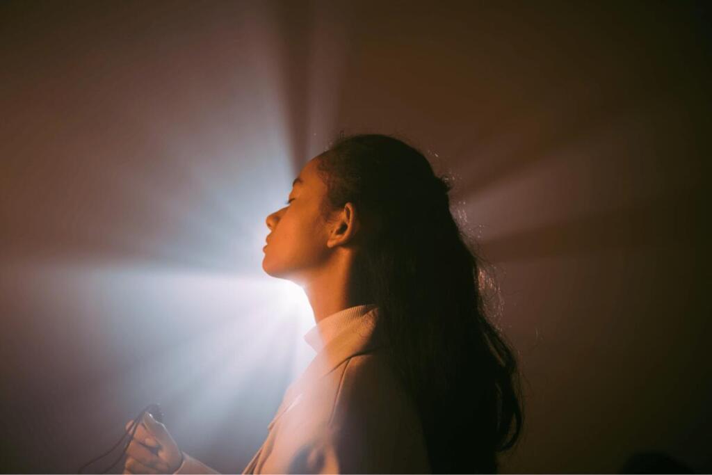 Woman illuminated by light rays