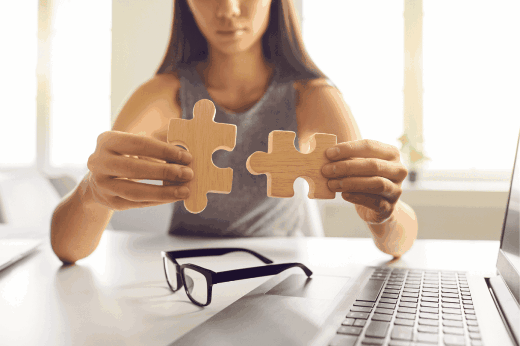 Woman problem solving with two puzzle pieces as a benefit of coaching